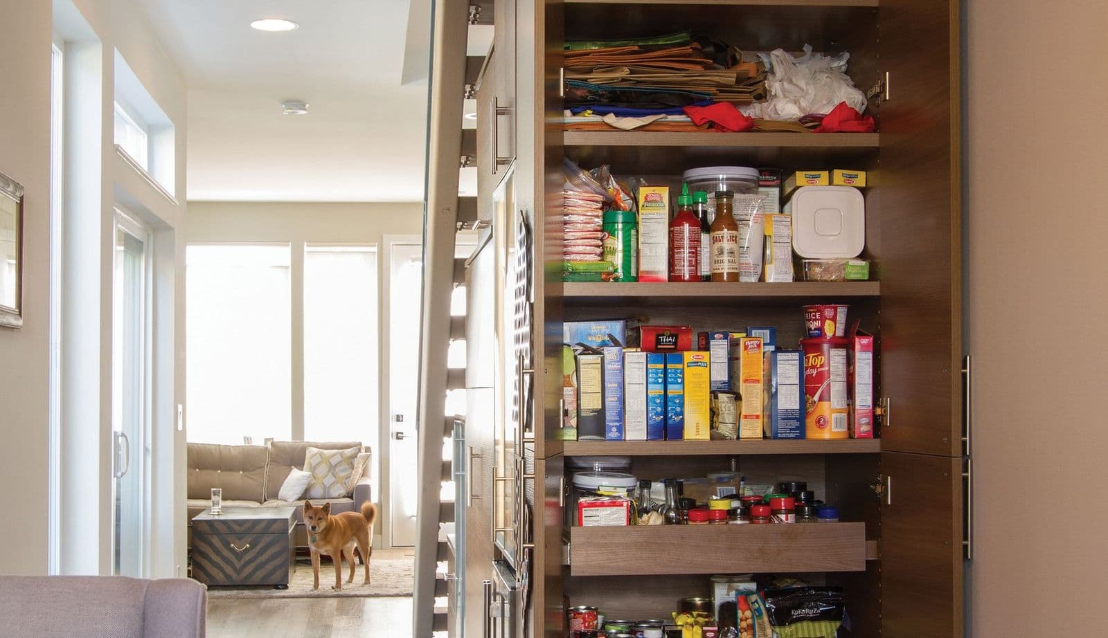 After image of custom kitchen pantry built in under stairwell with shelves and drawers in dark finish by California Closets